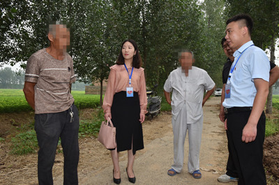 图为：为了更清晰地掌握这起纠纷的来龙去脉，司法所长张云飞、律师程喆来到争议的耕地地边，实地了解具体情况。.jpg