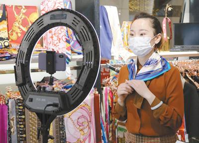 近日，北京秀水街大厦复工开业，图为一位经营者通过手机直播销售商品。